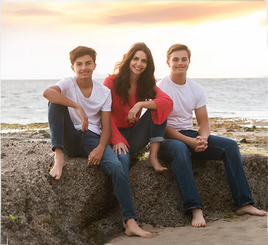 Bibi with her two sons on the rocks at the beach